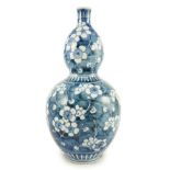 A Japanese blue and white 'prunus' double gourd sake flask, late Edo period, 31.5cm high***CONDITION