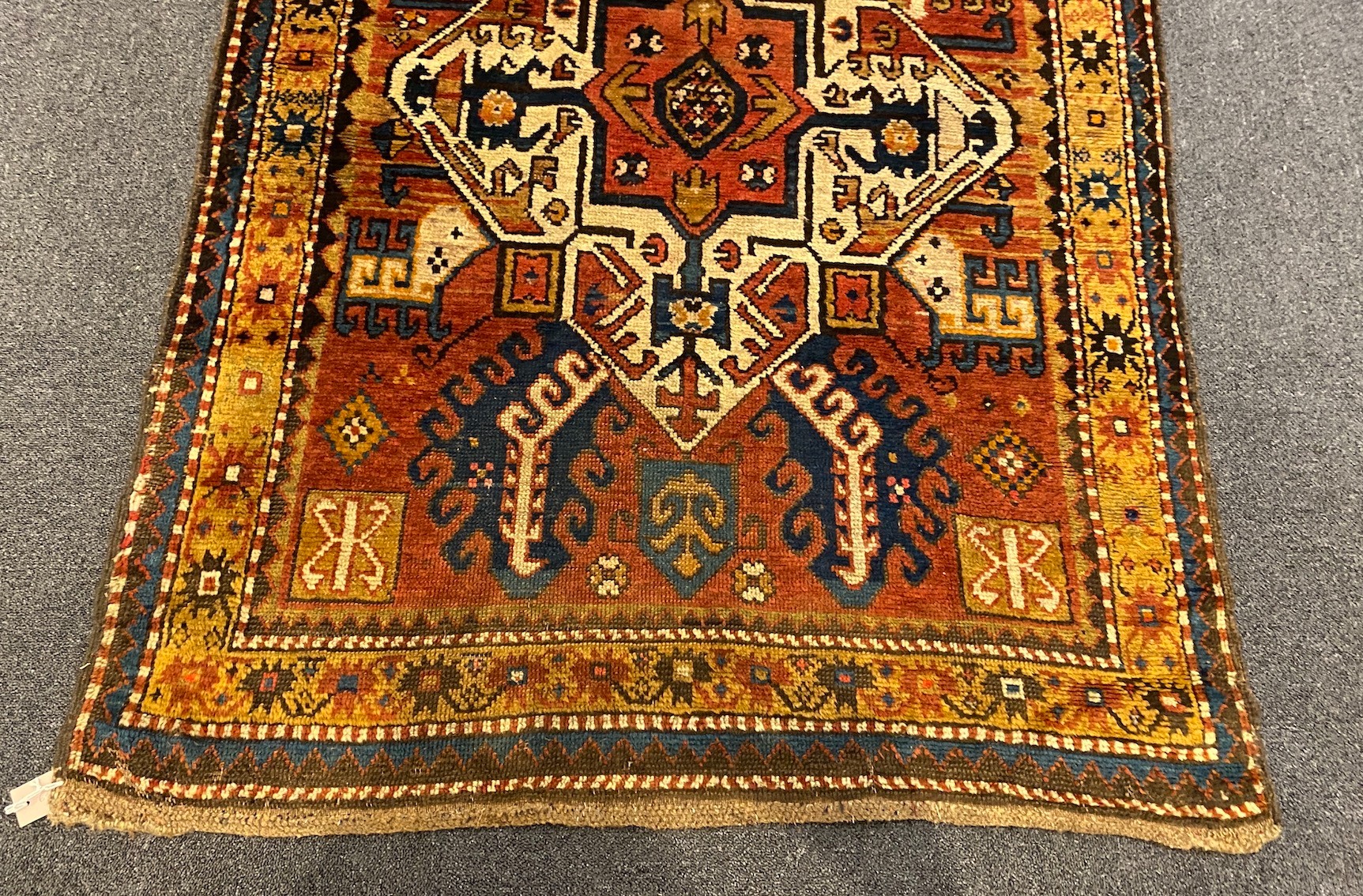 A Kazak red ground rug, with central medallions and geometric motifs, multi-bordered, 240 x - Image 2 of 5