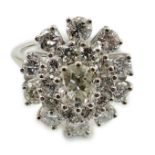 A platinum? and twenty one round cut diamond set oval cluster dress ring, the central stone weighing