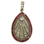 A 1920's pierced gold and platinum, millegrain set ruby and diamond oval pendant, set with round and