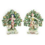 A good pair of Bow porcelain bocage figures, c.1770, modelled as a boy and a girl holding the lid of
