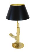 A Philippe Starck gilt metal kalashnikov table lamp, with gothic inscription happiness is a hot