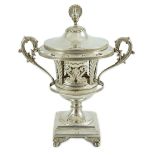 A 19th century ornate French pierced silver two handled urn shaped vase and cover, with peacock