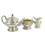 An Edwardian Scottish repousse silver three piece tea set, by Robert Scott, of inverted pear form