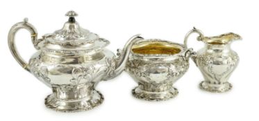 An Edwardian Scottish repousse silver three piece tea set, by Robert Scott, of inverted pear form