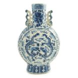 A Chinese blue and white ‘dragon’ moonflask, 19th century, each side painted with two confronting