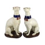 A pair of Italian tin-glaze earthenware figures of seated greyhounds, 35cm high***CONDITION