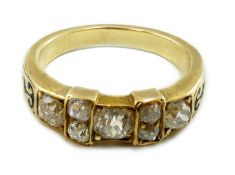 A late 19th century gold and seven stone old mine cut diamond and black enamelled cluster half