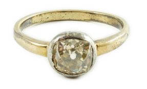 An antique yellow metal and collet set solitaire old cushion cut diamond ring, size N, gross