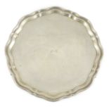 A George V shaped circular silver salver by Viners Ltd, with wavy border and engraved initials, on