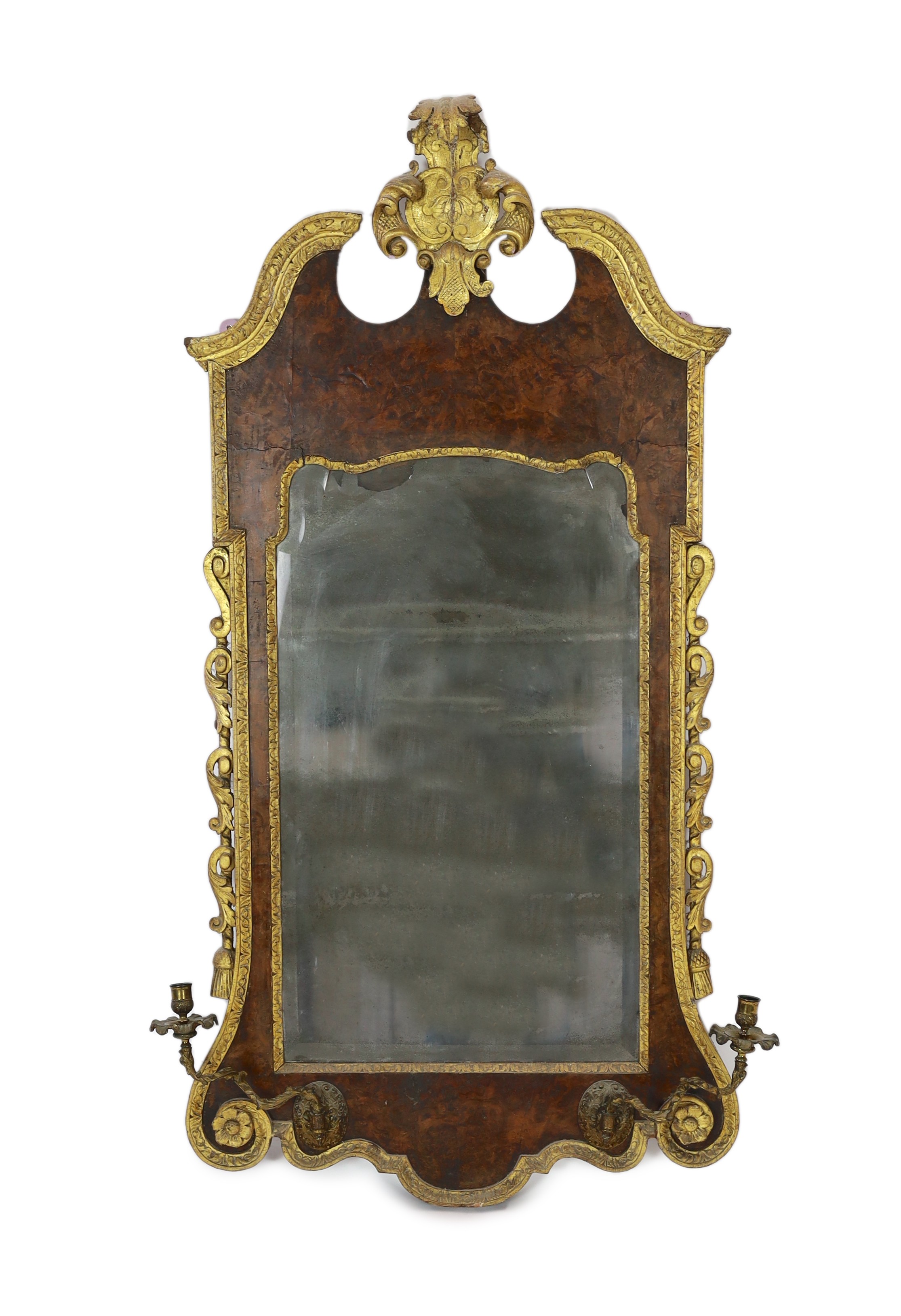 A George II and later carved giltwood and burr walnut wall mirror, the cartouche shaped crest