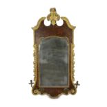 A George II and later carved giltwood and burr walnut wall mirror, the cartouche shaped crest