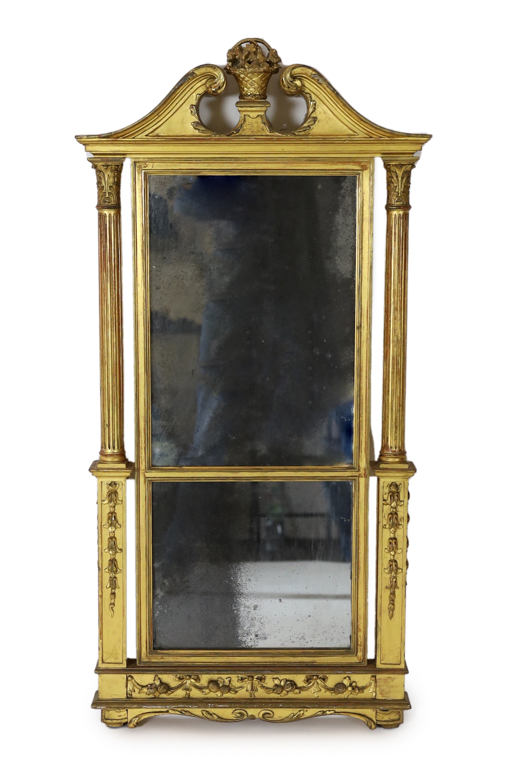 A George III giltwood pier glass, the tabernacle style frame with flowers in a basket and swans neck