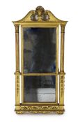 A George III giltwood pier glass, the tabernacle style frame with flowers in a basket and swans neck
