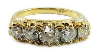 An 18ct gold and graduated five stone diamond set half hoop ring, with carved setting and diamond