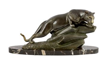 M. Leducq. A patinated spelter model of a panther crouched upon a rock, signed, on oval marble