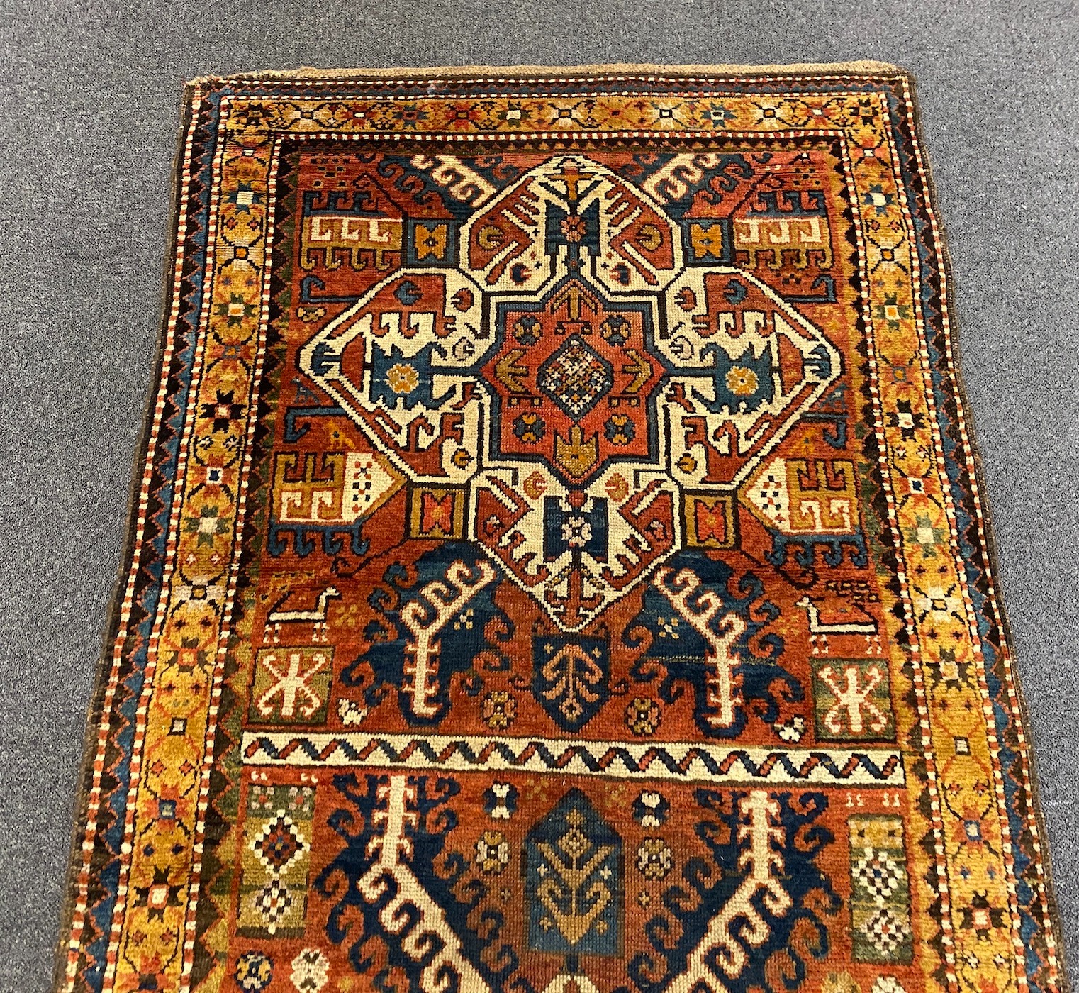 A Kazak red ground rug, with central medallions and geometric motifs, multi-bordered, 240 x - Image 4 of 5
