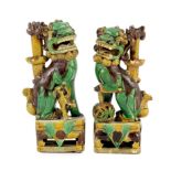 A pair of Chinese sancai-glazed biscuit Buddhist lion joss stick holders, Kangxi period, 15.5 and