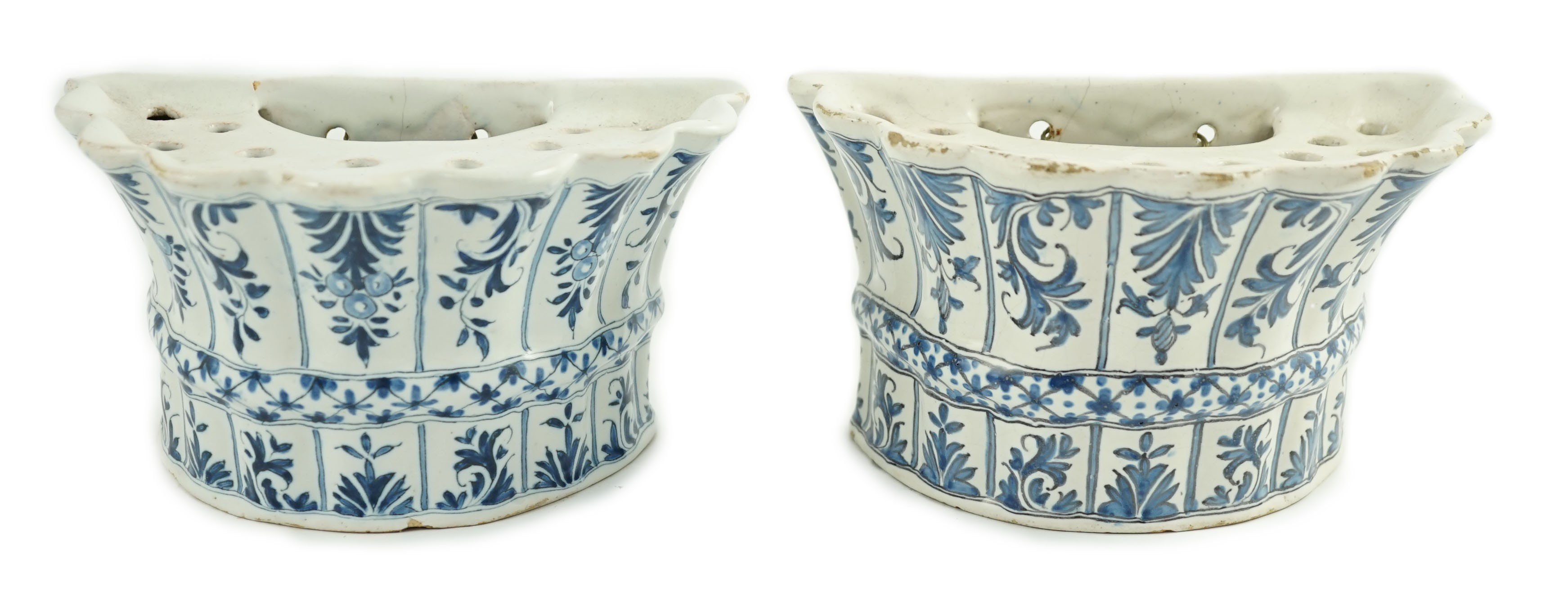 Two similar 18th century Delft blue and white hanging bough pots, of lobed demi-lune shape,