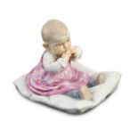 A rare Meissen porcelain figure of a child on a pillow, designed by Conrad Hentschel, c.1905,