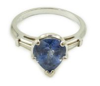 A platinum (10%) and single stone pear cut Ceylon sapphire set ring, with tapered baguette cut