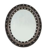 A 19th century Irish oval wall mirror, the ebonised and silvered frame applied faceted and