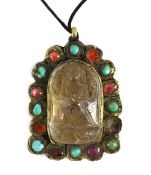 A Tibetan rock crystal and gem set pendant, 19th century, the central arched rock crystal carved
