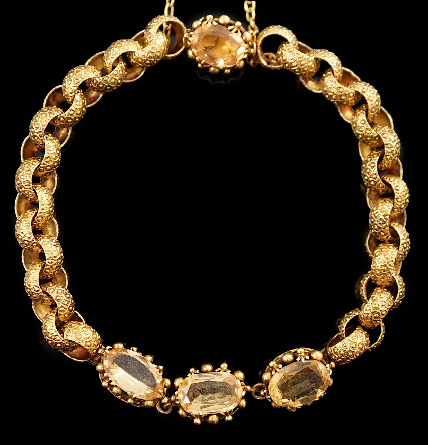 A 19th century cannetille work gold and four stone oval cut citrine set circular link bracelet,