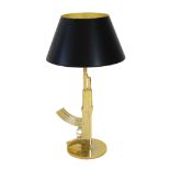 A Philippe Starck gilt metal Kalashnikov table lamp, with gothic inscription happiness is a hot