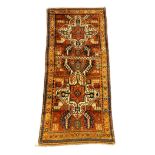 A Kazak red ground rug, with central medallions and geometric motifs, multi-bordered, 240 x