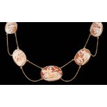 A late Victorian gold and graduated oval cameo shell necklace, with twin strand fine chain links and