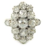 An 18ct gold and oval diamond cluster dress ring, with diamond set shoulders, set with seventeen