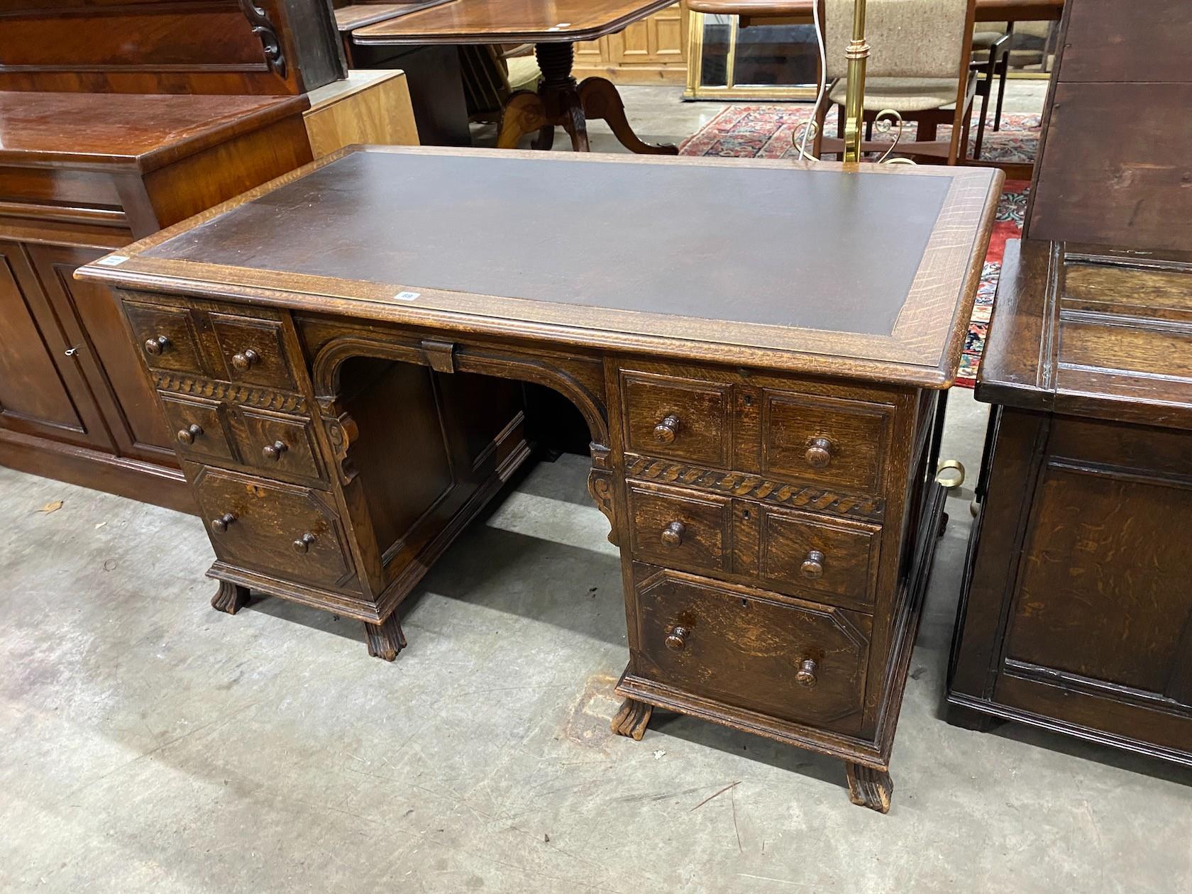 An early 20th century oak kneehole desk, length 136cm, depth 75cm, height 75cm