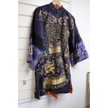 A 20th century Chinese robe, decorated with navy ground and gilt thread all over five claw dragons