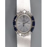 A lady's French 750 white metal Omega manual wind oval wrist watch, with sapphire and diamond set