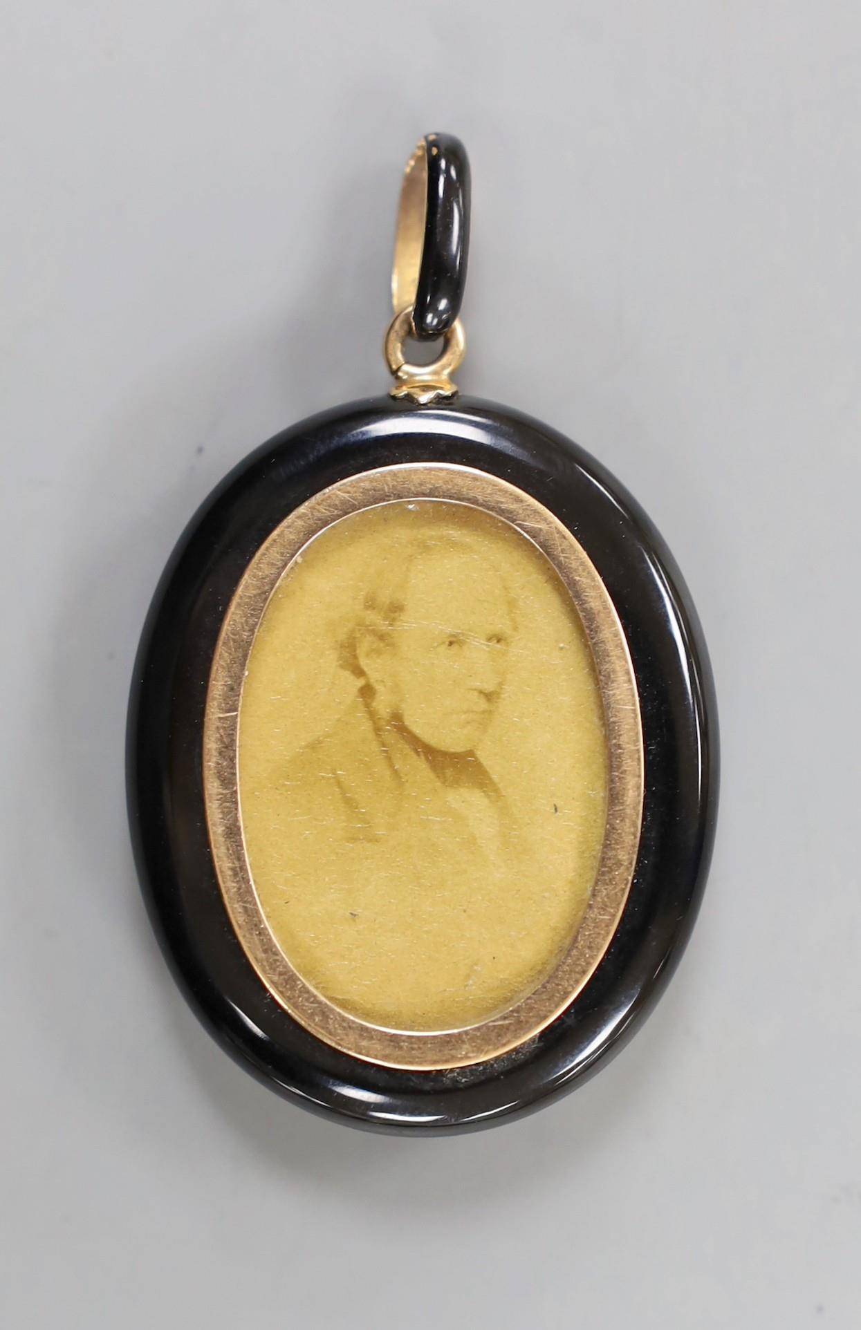 A Victorian black enamelled yellow metal oval locket, set with an old cut white sapphire, overall