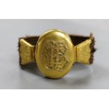 A Victorian yellow metal and hairwork bracelet with central photographic locket, central motif 44mm,