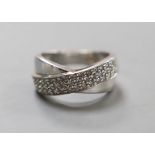 A modern 14k white metal and three row diamond chip set crossover ring, size N, gross weight 5.8