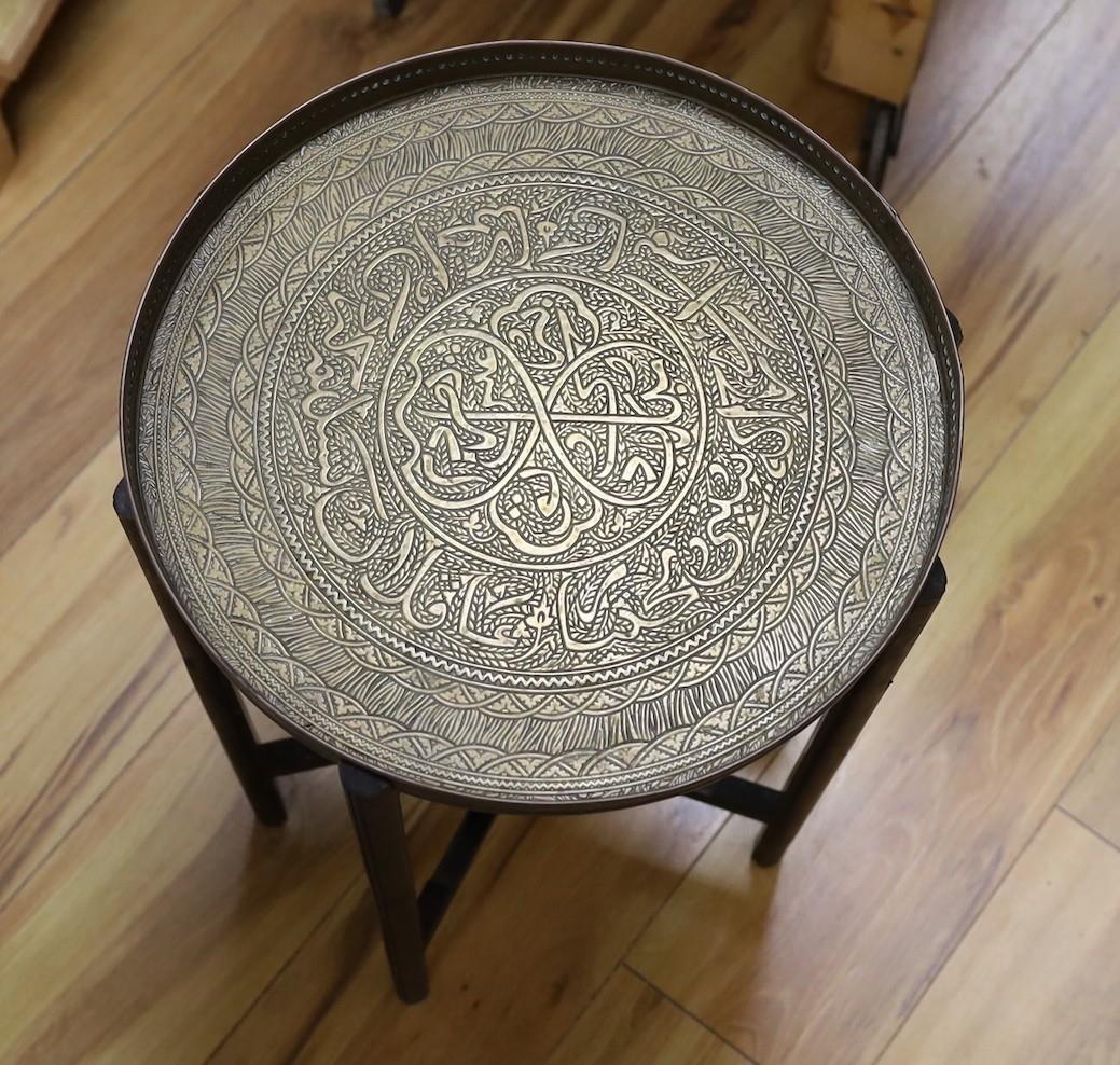 Benares brass folding table on wooden stand, 52cm tall, together with a three-footed lion pawed coal - Image 2 of 2