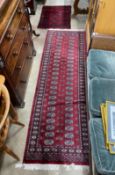 A Bokhara red ground runner and an Afghan rug, larger 250cms x 80cms.