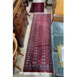 A Bokhara red ground runner and an Afghan rug, larger 250cms x 80cms.