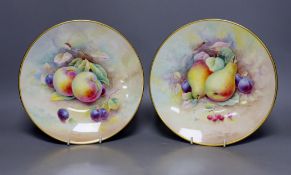 A pair of Minton fruit painted plates, signed A. Holland, 23cm diameter, together with two books