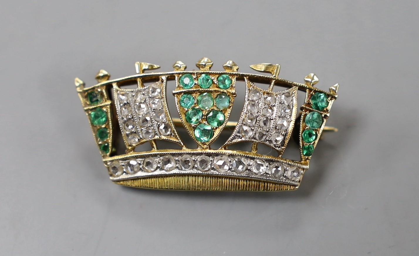 An early 20th century yellow metal, emerald and diamond set coronet brooch, 30mm, gross weight 4.4