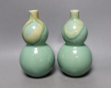 A pair of Chinese celadon ground bottle vases 21cm tall