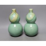 A pair of Chinese celadon ground bottle vases 21cm tall