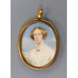 A yellow metal mounted oval portrait miniature of a young lady pendant miniature, the glazed back