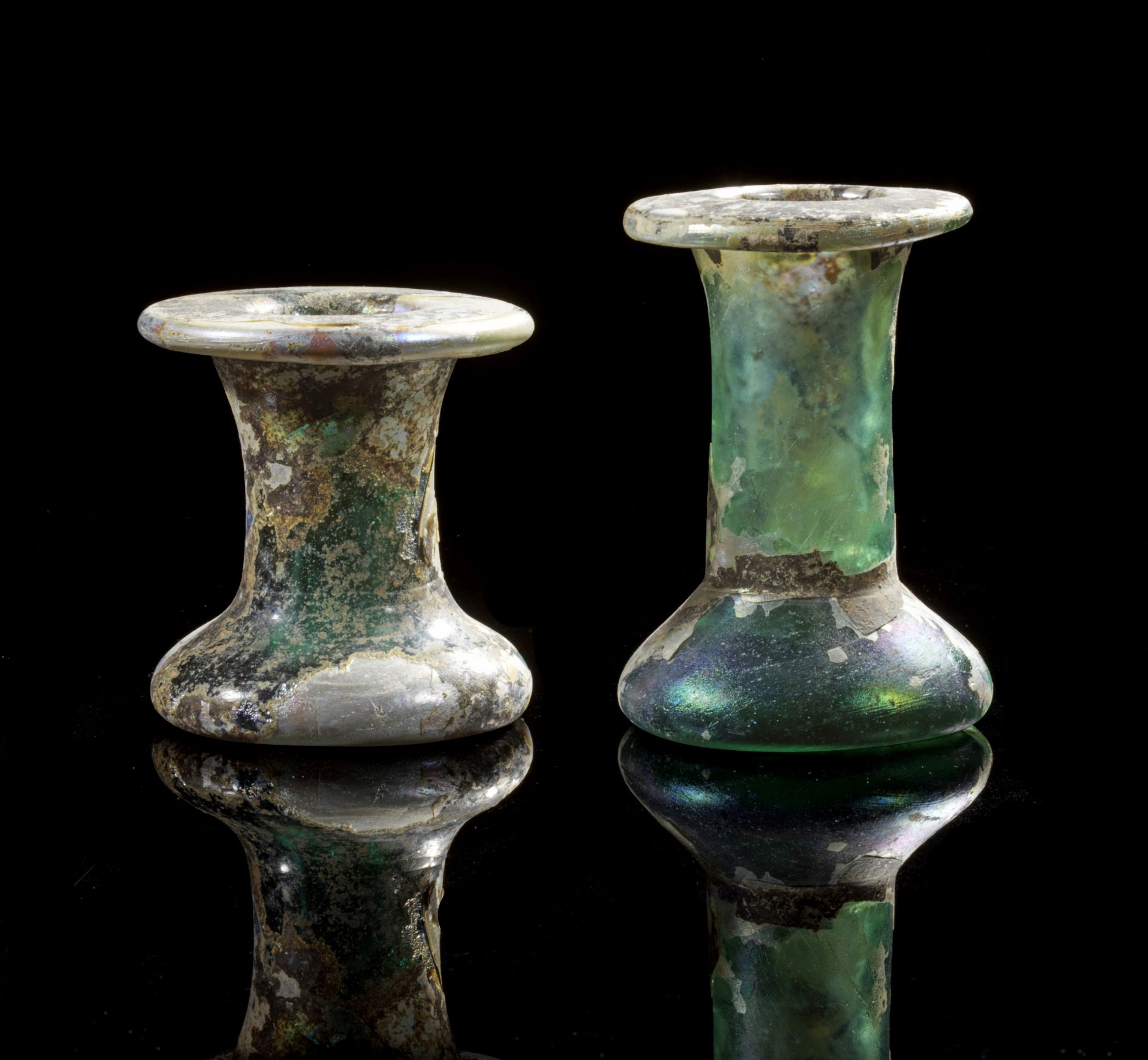 Two unguentaria made of thick, greenish glass with broad outsplayed rim.