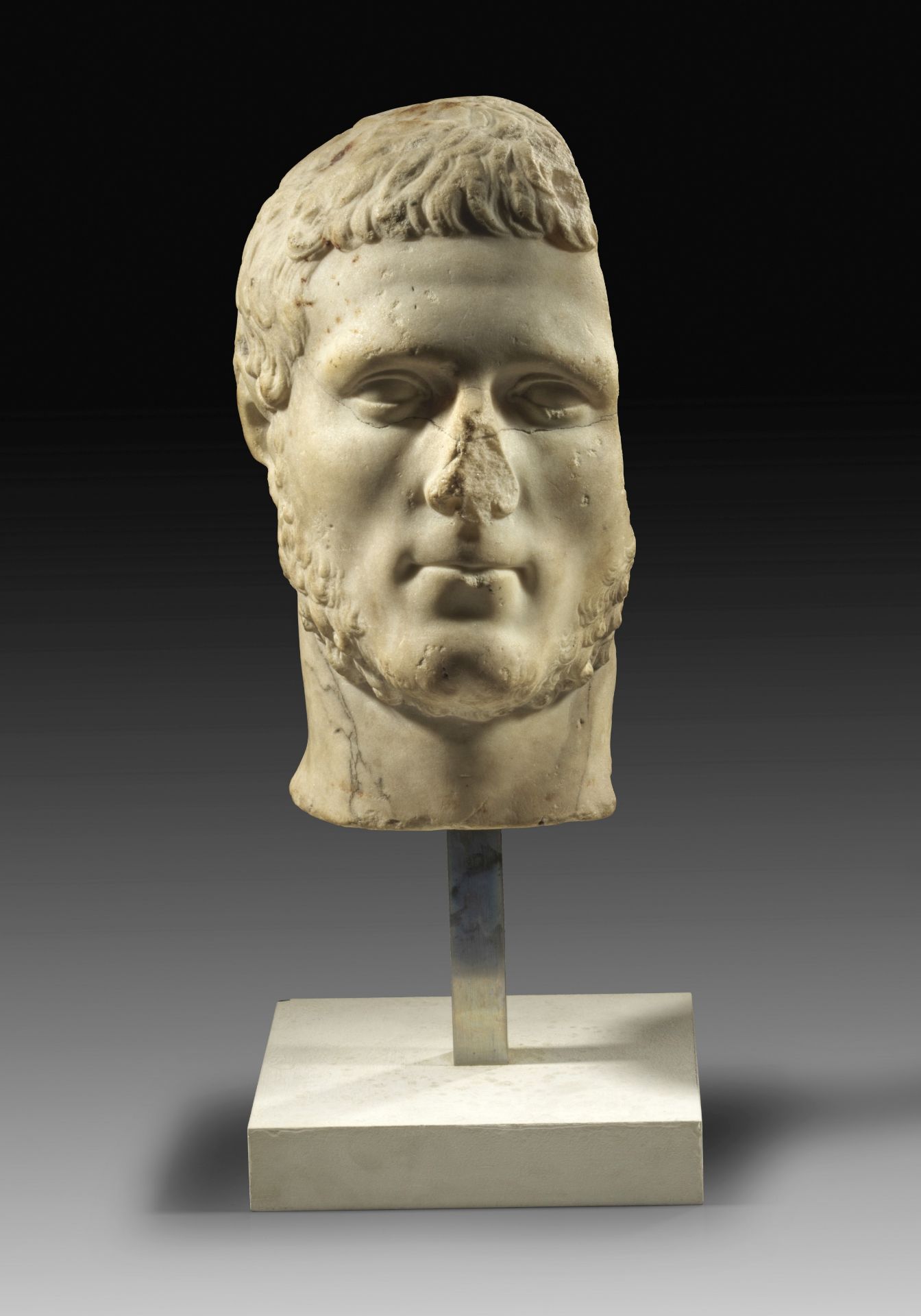 Marble portrait of young roman man with long sideburns. 