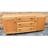 AN ERCOL WINDSOR BLONDE ELM SIDEBOARD MODEL 455 with three central drawers flanked by a cupboard