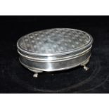 A SILVER BOX THE BOX of oval form and on four splayed feet, the lid of engine turned pattern with